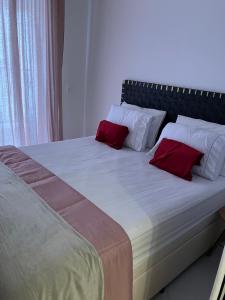 Una cama grande con almohadas rojas encima. en São Paulo - Vila Mariana - Central en São Paulo