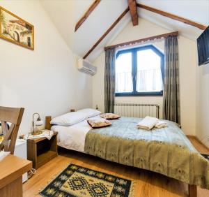 una camera da letto con un letto e una finestra di Hotel Kandilj a Sarajevo