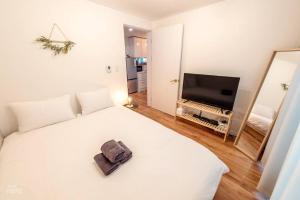 a bedroom with a white bed and a television at Lazo House in Seoul