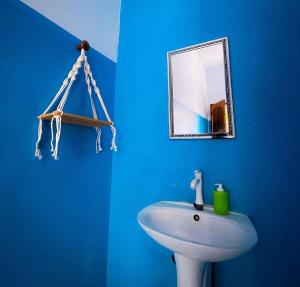 een blauwe badkamer met een wastafel en een spiegel bij Pandan Wangi in Nusa Lembongan