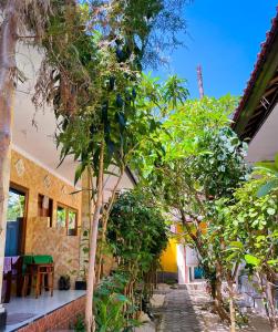 a house with a garden with trees in front of it at Pandan Wangi in Nusa Lembongan