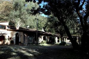 ein altes Gebäude mit Bäumen davor in der Unterkunft La Francesca Sud un villaggio"glamping" in Scario