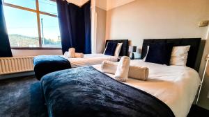 2 camas en una habitación de hotel con ventana en Modern Contractor Housing - FREE WiFi and parking!, en Luton