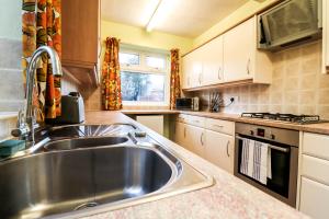 cocina con fregadero y fogones en Modern Contractor Housing - FREE WiFi and parking! en Luton