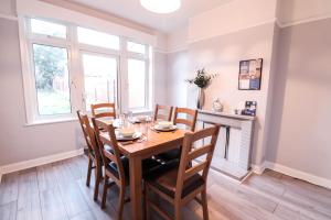 comedor con mesa de madera y sillas en Modern Contractor Housing - FREE WiFi and parking!, en Luton