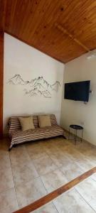 Paraíso Ushuaia في أوشوايا: غرفة بها سرير وتلفزيون على الحائط