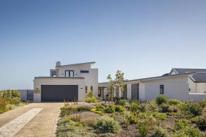 a large white house with a garage at Coastal Retreat, wine and relax in Hermanus