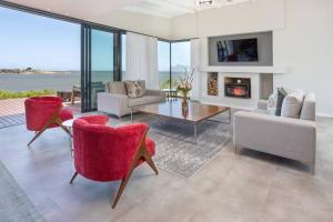 a living room with red chairs and a fireplace at Coastal Retreat, wine and relax in Hermanus