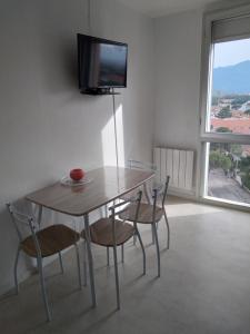 濱海阿熱萊斯的住宿－Argeles plage，餐桌、椅子和墙上的电视