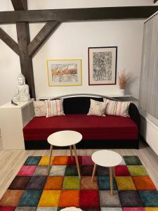 een woonkamer met een rode bank en 2 tafels bij Ferienwohnung Atelier in Siegsdorf