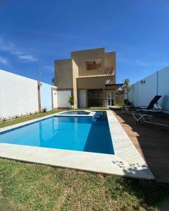 a swimming pool in front of a house at Pousada La Belle de Jour in Chapada dos Guimarães
