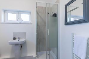 a bathroom with a shower and a sink and a mirror at The Eldern - Spacious, Netflix, free Parking, close to A1 in Peterborough