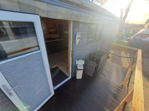 a sliding glass door on a house with a porch at Tiny House Flensburg Luv in Hornholz