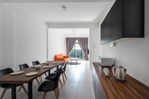 uma cozinha e sala de jantar com mesa e cadeiras em ALOR SETAR IMPERIO PROFESSIONAL SUITE by Zenith Smart em Alor Setar