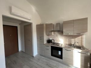 uma cozinha com um lavatório e um fogão forno superior em AIR σϝ HOME Aραɾƚɱҽɳƚ ᴠᴇʀᴅɪ em Novi Ligure