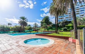 una piscina en un patio con palmeras y un edificio en Lovely Apartment In Estepona With House A Mountain View, en Estepona