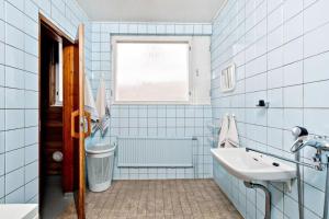 a blue tiled bathroom with a sink and a window at Omakotitalo, Pansio (near Meyer gate) in Turku