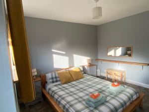 a small bedroom with a bed with a plaid blanket at The Annexe in Filey