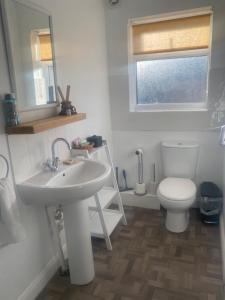 a bathroom with a white sink and a toilet at The Annexe in Filey