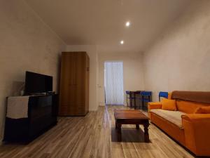 een woonkamer met een bank en een tv bij Soleluna in Piacenza