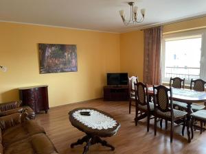 een woonkamer met een bank en een tafel bij LUX APARTAMENT in Giżycko