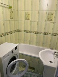 een badkamer met een wasmachine en een wastafel bij LUX APARTAMENT in Giżycko
