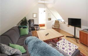 a living room with a couch and a table at Amazing Home In Sams With Wifi in Nordby