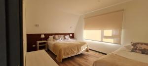 ein kleines Schlafzimmer mit zwei Betten und einem Fenster in der Unterkunft Patagonia Route Apartments in Puerto Varas