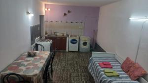 Habitación pequeña con mesa y cocina en Departamento La Argentina en San Luis