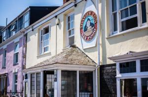 a building with a sign on the side of it at Lovely 1-bedroom serviced apartment in Falmouth in Falmouth