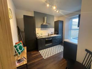 een kleine keuken met een wastafel en een aanrecht bij Lovely 1-bedroom serviced apartment in Falmouth in Falmouth