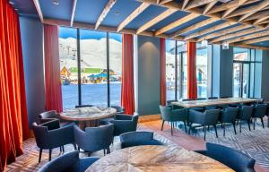 un restaurant avec des tables et des chaises et une grande fenêtre dans l'établissement New Gudauri Twins 126, à Goudaouri
