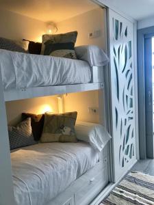 a bedroom with two bunk beds with white sheets at Nievemar Edificio Monte Oiz in Sierra Nevada