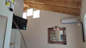 espejo y TV en una habitación con techo en Lesvos Tavari bay en Tavari