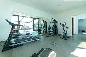 a gym with several treadmills and elliptical machines at Sea House Resort in Brela