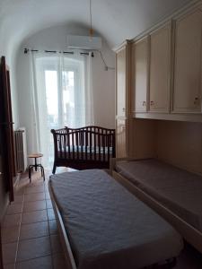 een slaapkamer met een bed, een stoel en een raam bij Casa Santa Chiara in Mola di Bari
