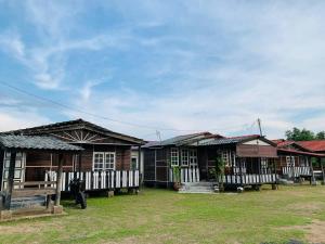 a group of wooden houses in a field at MOSS HEDERA HIDE CHALET in Melaka