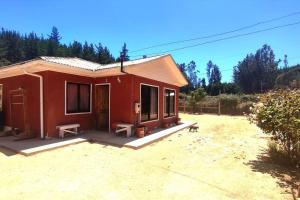 比奇烈穆的住宿－Casa de Campo a pasos del Estéreo，坐在院子里的一间红色小房子
