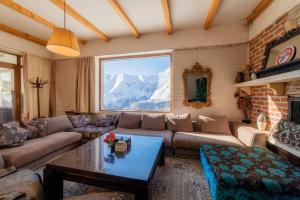 a living room with a couch and a table at Snow Time Cottage in Gudauri