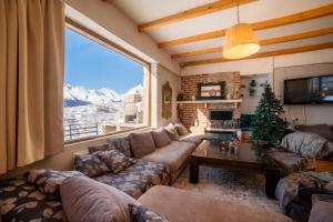 a living room with a couch and a christmas tree at Snow Time Cottage in Gudauri