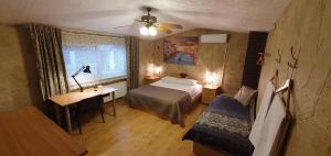 1 dormitorio con cama, escritorio y ventana en Cosy House Billiard - Sauna & Parking, en Kaunas