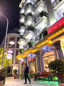 Halong Boutique Hotel في ها لونغ: رجل يمشي امام مبنى