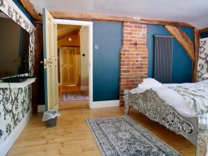 Habitación con cama y pared de ladrillo en Captivating 9-Bed House Hot Tub Near Cambridge, en Saffron Walden