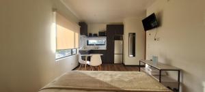 1 dormitorio con cama, escritorio y cocina en Patagonia Route Apartments, en Puerto Varas