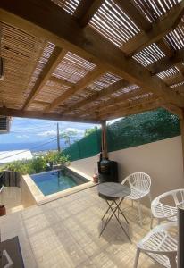 un patio con mesa y sillas y una piscina en Villa Morin en Bernica-les Bas