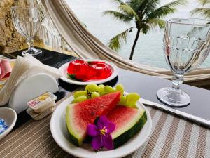 um prato de melancia e uvas numa mesa com copos de vinho em Vivalavida Serra&Mar em Angra dos Reis