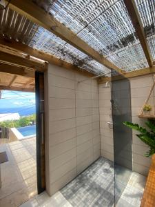 una doccia esterna con porta in vetro e soffitto di Villa Morin a Bernica-les Bas