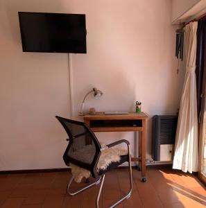 Habitación con escritorio, silla y TV. en Lindo y cómodo departamento en Pinamar - Otilia Residencias en Pinamar