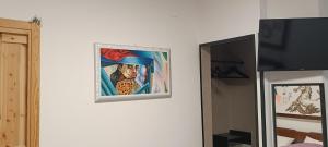 une peinture accrochée sur un mur à côté d'une télévision dans l'établissement A letto nell'Arte, à Ascoli Piceno