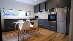 eine Küche mit Tisch und Stühlen und einem Kühlschrank in der Unterkunft Patagonia Route Apartments in Puerto Varas + 30 Fotos